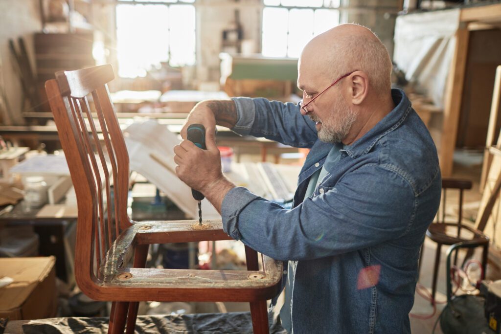 Senior Man Mastering Upholstery In Workshop