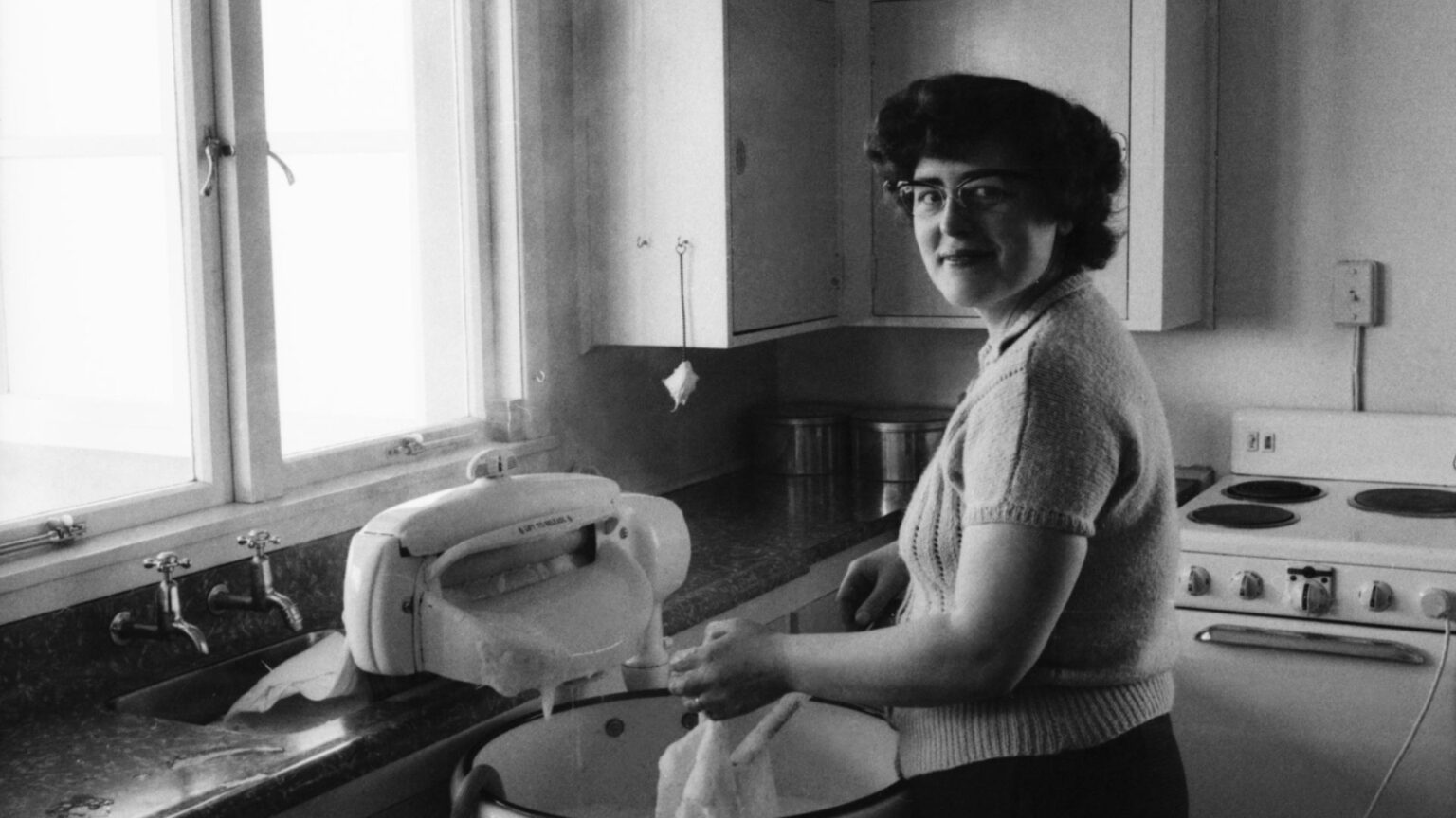 A 1940s Housewife Using A hand Cranked Wringer Washing Machine—Nostalgia Myths Debunked