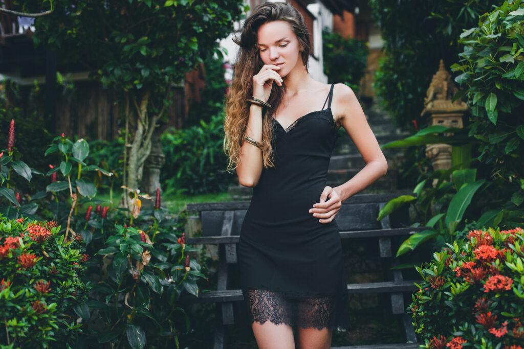 young beautiful sexy woman in tropical garden, summer vacation in thailand, slim skinny tanned body, little black dress with lace, natural look, sensual, relaxed,