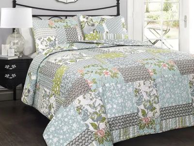 Farmhouse bedding with patchwork floral quilt in a bright country bedroom