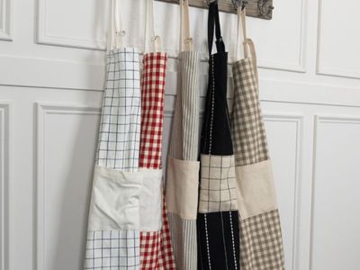 Classic farmhouse kitchen apron hanging from rustic wall hooks