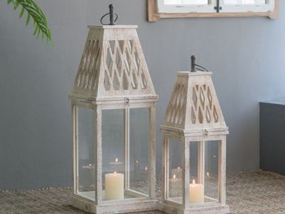 Rustic white farmhouse candle lanterns displayed on a table