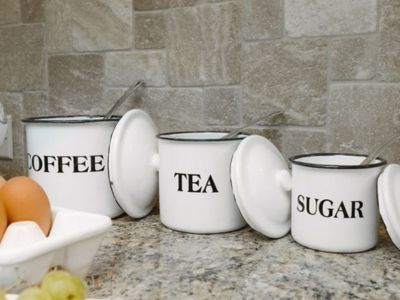 White enamel kitchen canisters labeled coffee tea and sugar