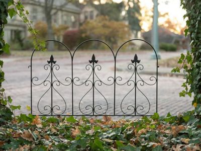 Ornate black metal decorative fence in a country garden